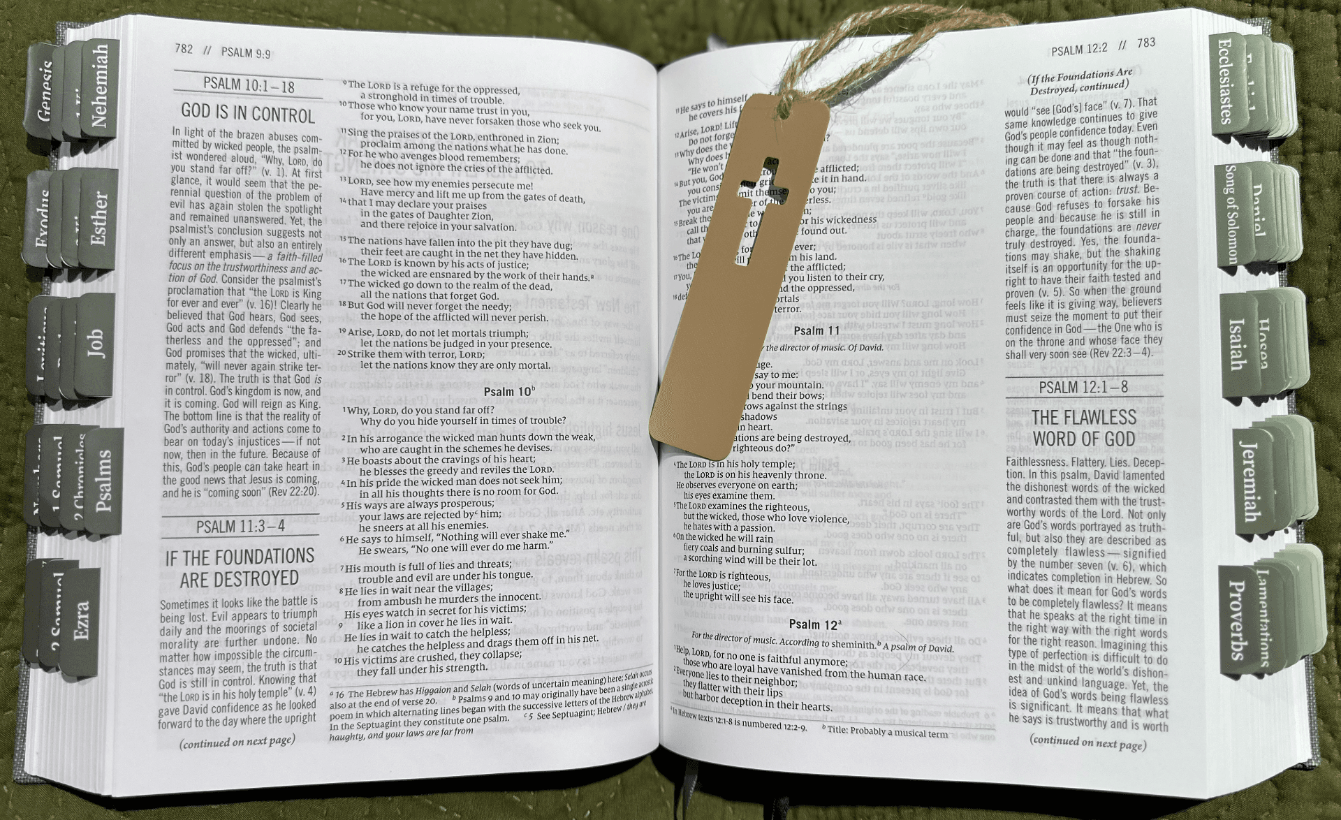 Marcador cruz vazada vista frontal sobre página de Bíblia