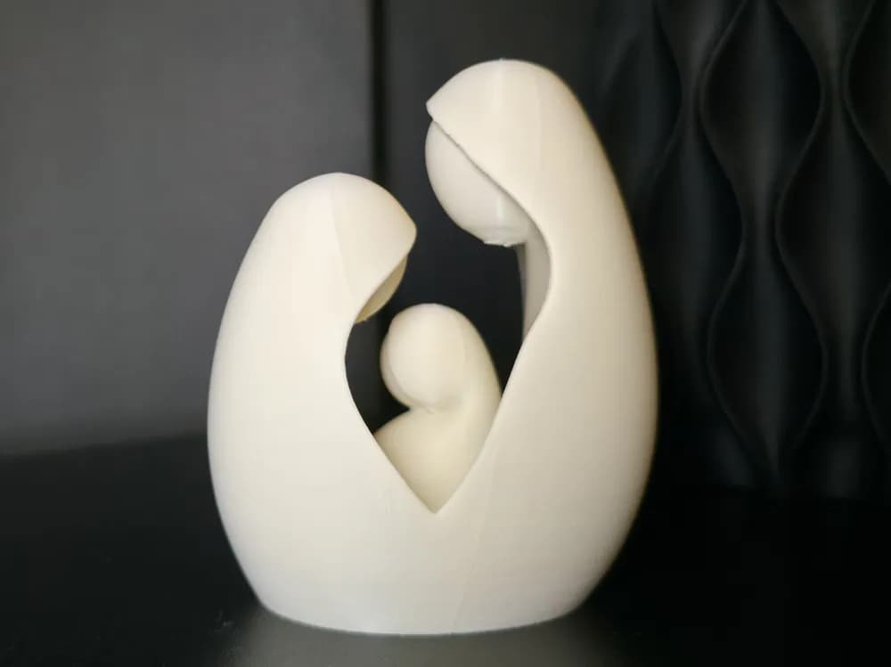 Ângulo lateral da escultura da Sagrada Família, mostrando o abraço de Maria e José ao redor do Menino Jesus